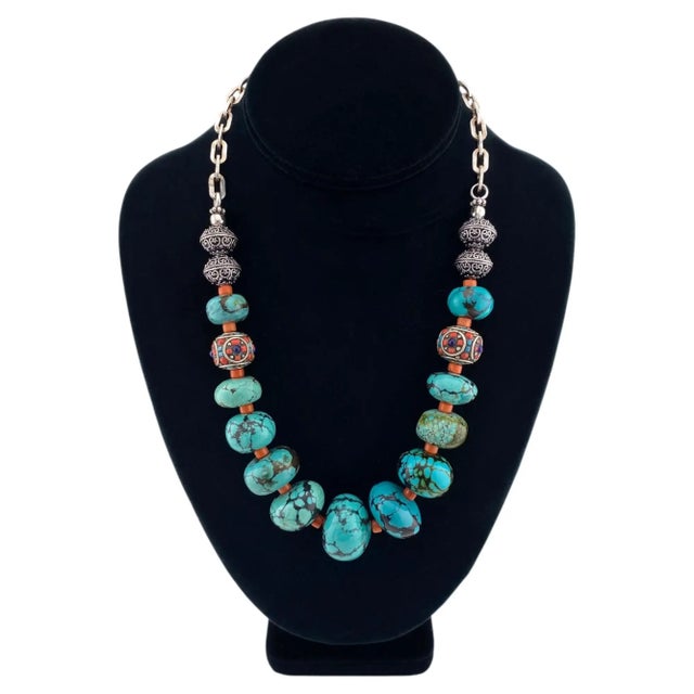 This necklace we created with up to 27mm Chinese turquoise beads, 3mm coral as spacer and decorated with two Tibetan hand...