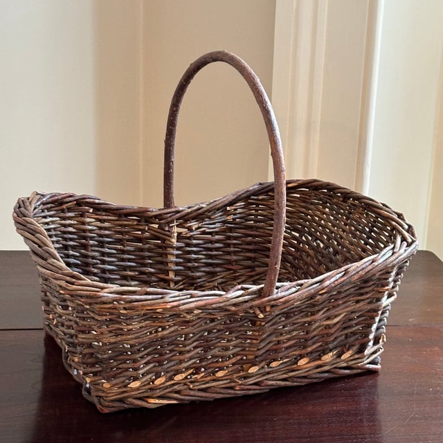 A beautifully hand-woven rustic-style vintage twig basket with tall handle. This is a wonderful gathering basket --...