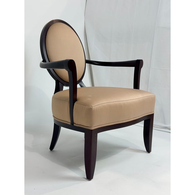 This is a refined armchair designed by Barbara Barry for Baker Furniture, distinguished by its classic oval medallion back...