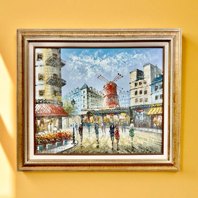 This vintage oil on canvas painting features a Parisian street scene centered on the iconic red windmill of the Moulin...