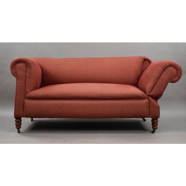 A charming and generously proportioned late Victorian one-arm drop-end sofa, dating to approximately circa 1890–1910. The...