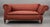 A charming and generously proportioned late Victorian one-arm drop-end sofa, dating to approximately circa 1890–1910. The...