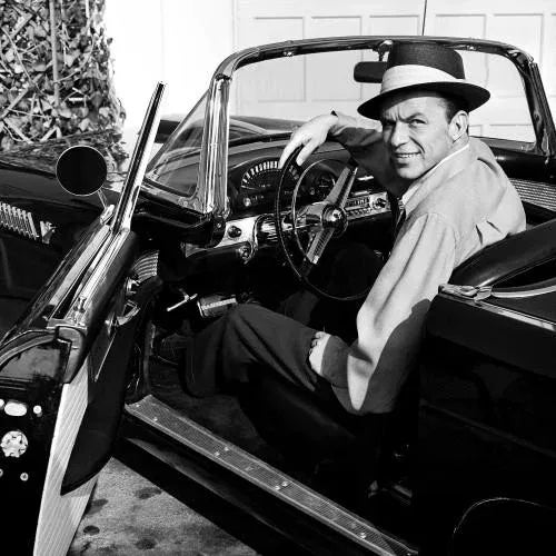 Frank Sinatra in Tbird In this photograph, Frank Sinatra is captured glancing over his shoulder at his friend,...