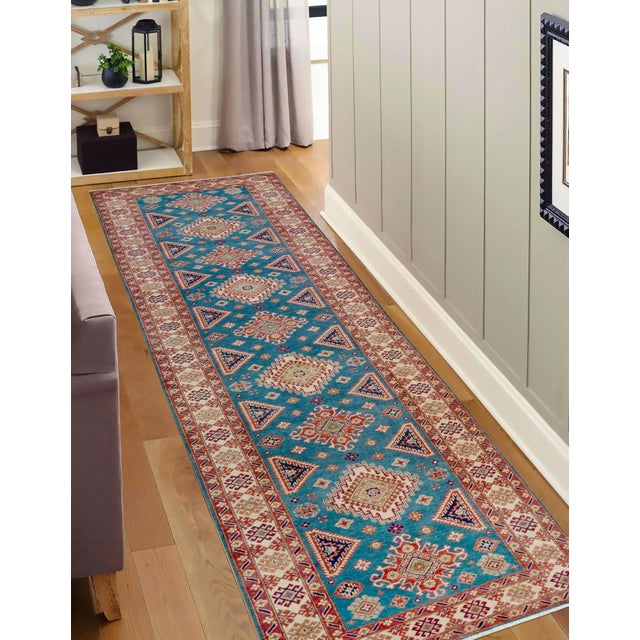 Enhance your home with this exquisite hand-knotted Kazak rug, crafted from fine hand-spun wool and dyed with all-natural...