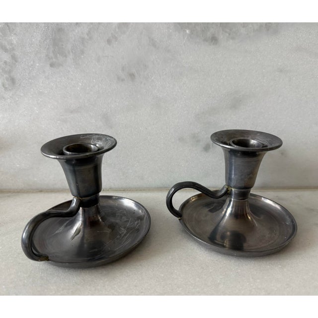 Pair of heavy vintage pewter chamberstick candle holders with a flared drip pan, curled finger-loop handles and removable...