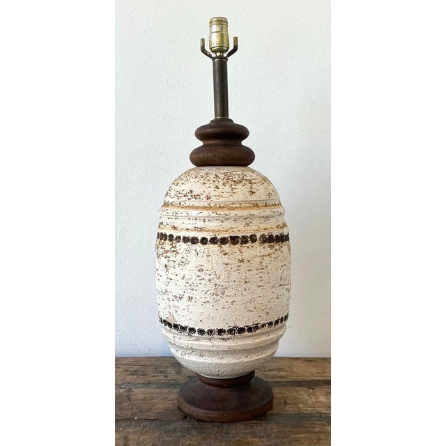 This striking mid-century modern table lamp is a masterclass in textural design, featuring a substantial ceramic body...