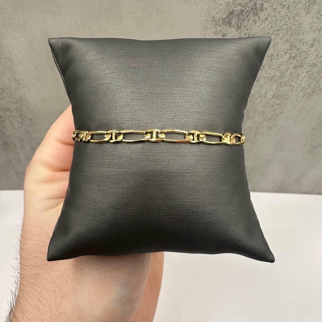 This elegant estate Figaro mariner link bracelet is crafted in 14K yellow gold and features a classic, timeless design...