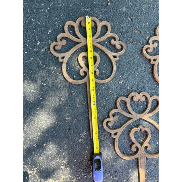 Wonderful and elegant set of 4 matching vintage cast iron ornamental garden stakes. They could also be used as hose...