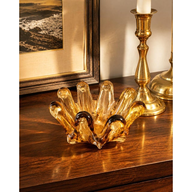 A striking vintage hand-blown art glass vessel in luminous amber with smoky espresso accents and an expressive biomorphic...