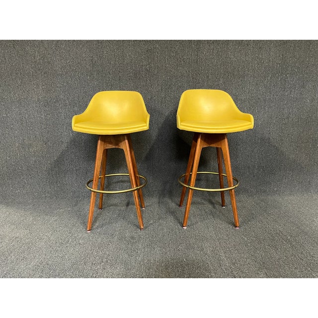 Here is a killer pair of vintage mid century bar stools by Chet Beardsley. Original yellow vinyl fabric is in great...