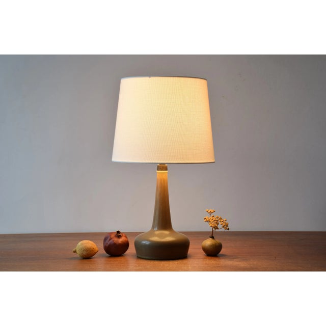 Palshus / Le Klint table lamp with brown haresfur glaze and patinated brass top. This lamp was designed by Esben Klint and...