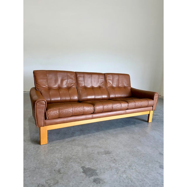 Vintage 1970’s Caramel Leather and Beech Wood 3 Seat Sofa. Cowboy/Baseball glove leather stitching details around arms and...