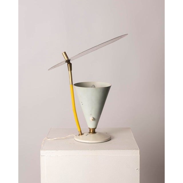 A unique Italian table lamp from the 1950s, crafted from lacquered metal and brass, with a distinctly Mid-Century Modern...
