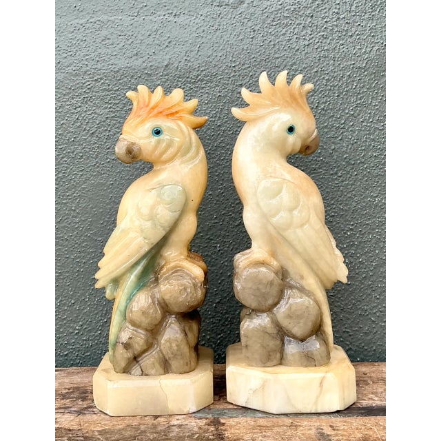 A pair of vintage cockatoo sculptures carved from onyx and alabaster, these decorative birds reflect the skilled artistry...