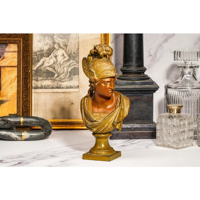 This striking antique cast metal bust captures the enduring allure of classical antiquity, likely dating to the late 19th-...