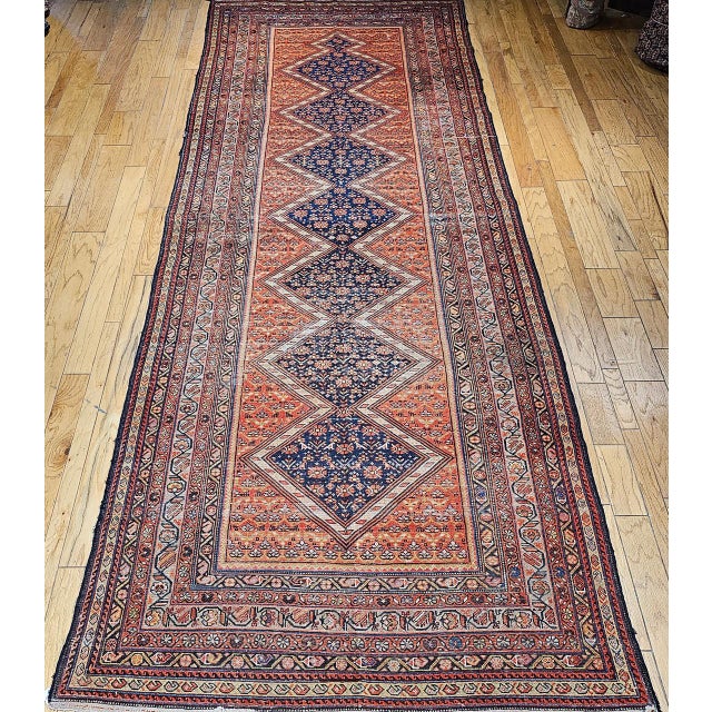 This early 20th century Persian Malayer gallery rug presents a compelling example of village weaving, defined by its...