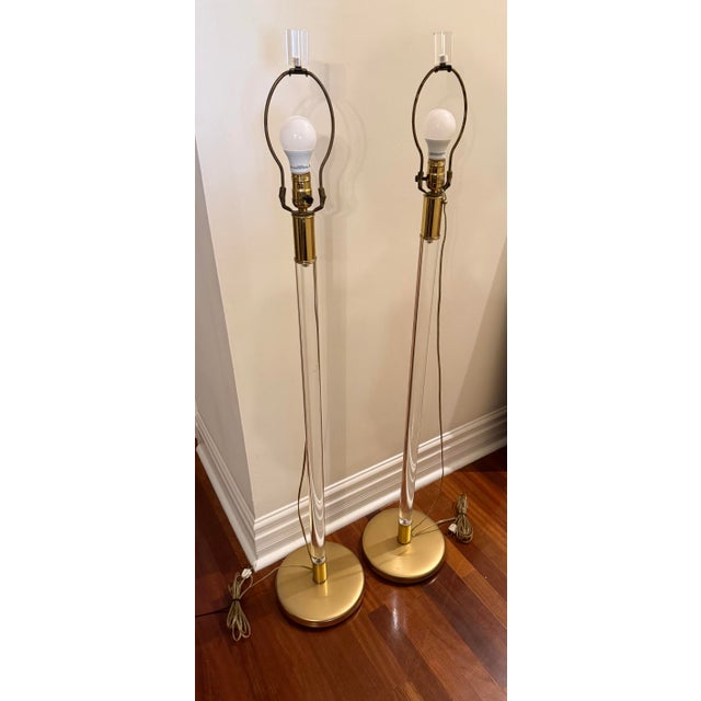 A striking pair of vintage floor lamps by Lang Levin Studios of Chicago, featuring tall faceted lucite columns rising from...