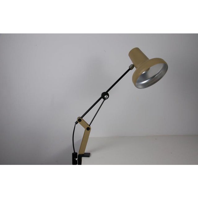 Adjustable mid-century task lamp from germany, 1970s, designed with a cream-colored metal shade, black articulated arm...