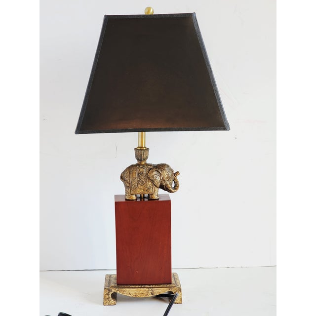 Vintage Bombay Company table lamp, featuring a bronze gilded Indian style elephant, seating ontop of a tall wood and metal...