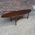 This classic Mid-Century Modern "surfboard" style coffee table features an elongated, tapered oval top supported by an...