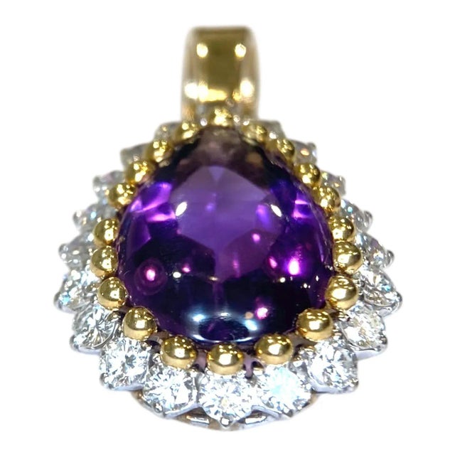 Crafted in 14K yellow gold, the pendant features a pear-shaped amethyst cabochon surrounded by brilliant-cut diamonds. The...