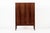 This exceptional vintage mid century Danish modern rosewood cabinet in the manner of Kaare Klint is circa 1960. This tall...