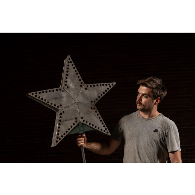 A bold five-point punched-tin star fitted with a long mounting post, originally designed to glow from within. Each panel...
