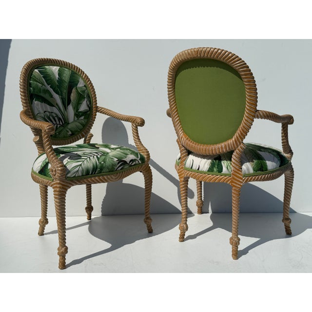 Pair of hand carved faux bois rope and tassel Palm Beach Regency arm chairs upholstered in tropical Floridian fabric.