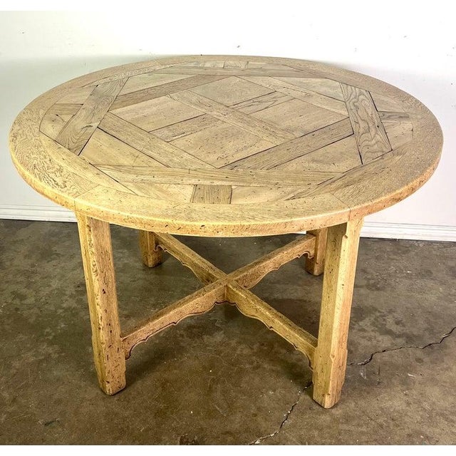 19th C. English round wooden table with a rustic, handcrafted appearance. The tabletop has an intricate design, with...