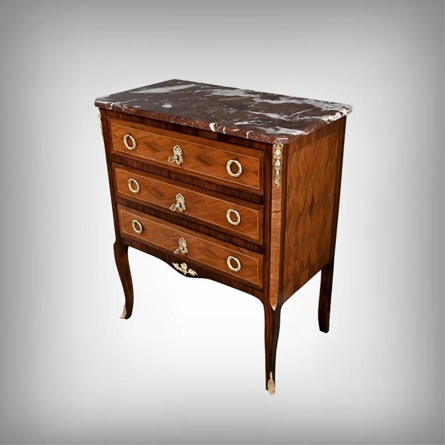This mahogany and rosewood marquetry commode, crafted in the Transitional style, is distinguished by the subtle harmony...