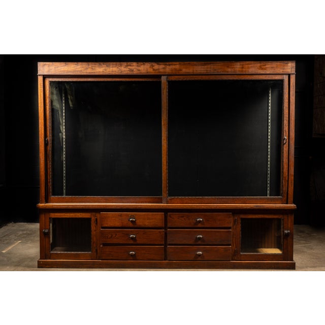 Large quarter-sawn oak display cabinet executed in a restrained commercial style and designed for retail, institutional,...