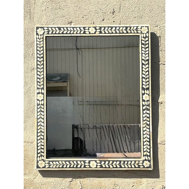This stunning vintage mirror features an intricately hand-crafted bone inlay frame, showcasing an elegant floral and vine...