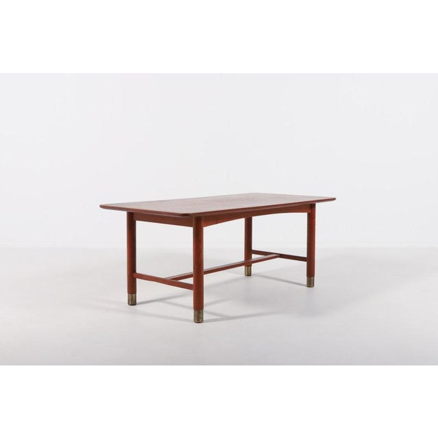 Swedish Modern coffee table in teak from 1960s with brass feet covers, designed by Carl-Axel Acking. Condition Good, age...