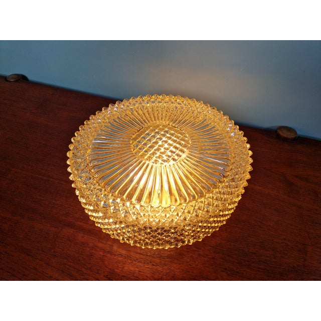 Amber crystal ceiling light with a gold-tone metal base, dating from the 1970s, likely produced by the German manufacturer...