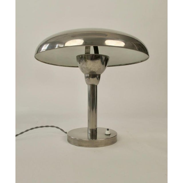 A Bauhaus desk lamp in chrome plated metal. Looking at the lamp from the side you will discover a sculptural form, with...