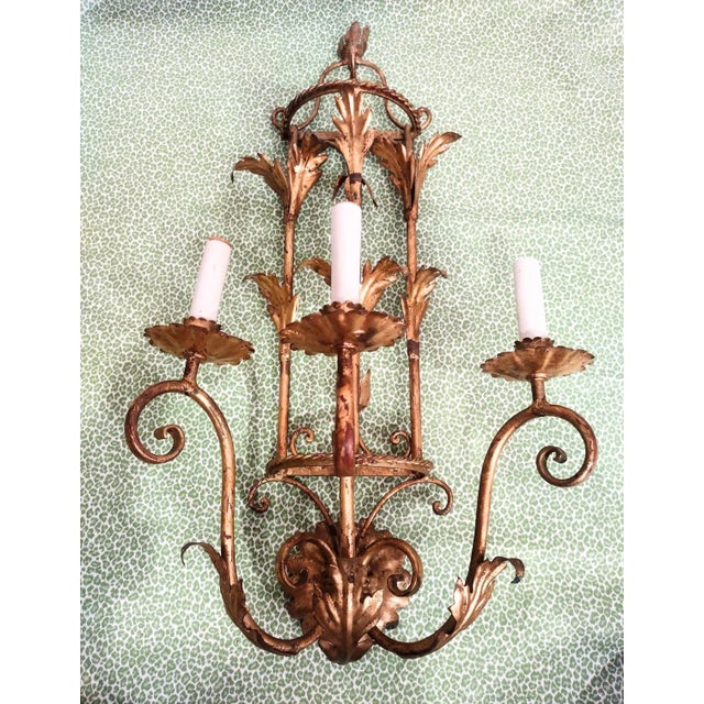 A beautiful large vintage 3 arm pagoda style wall sconce light fixture. The fixture features pretty leaf and curl details...