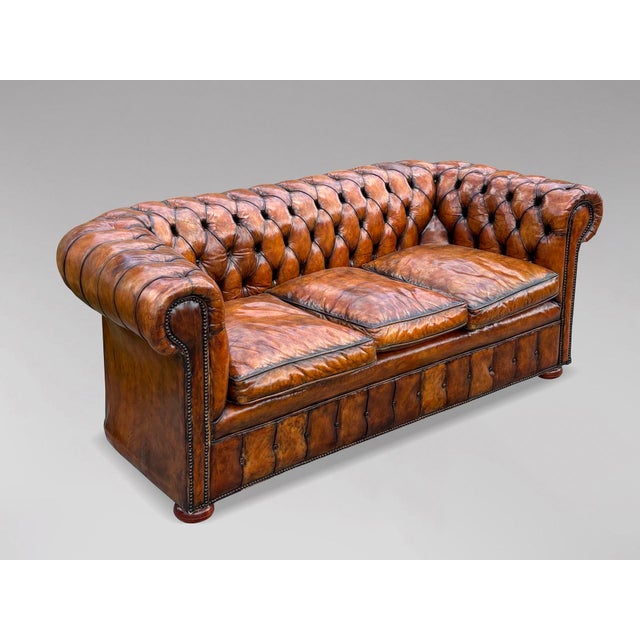 A stunning late 19th-century Victorian three-seater brown leather Chesterfield sofa with three loose feather filled...