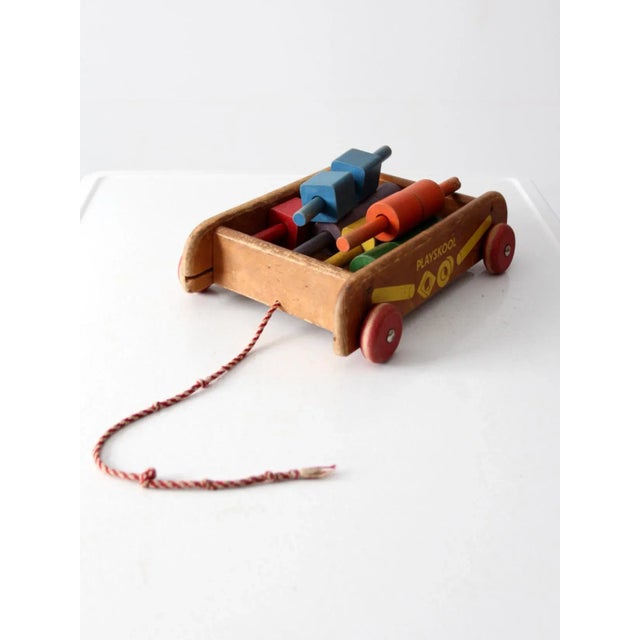 A vintage Playskool wooden pull wagon with classic building blocks. features a wheeled wood cart with pull string and a...