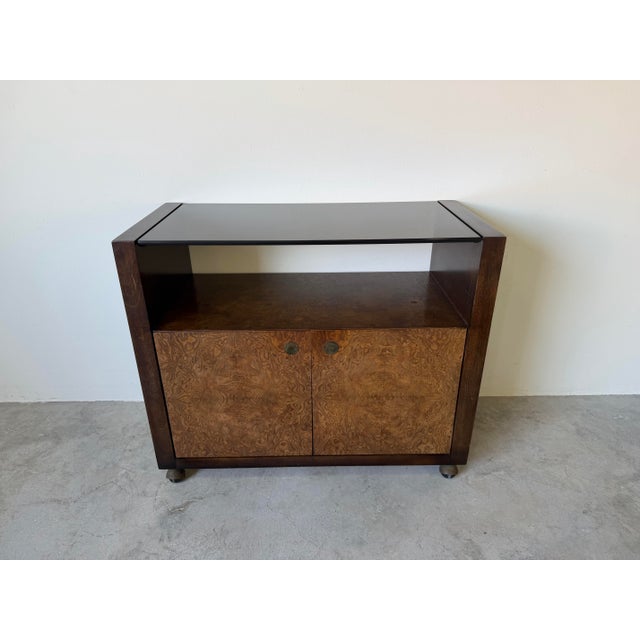 Striking Mid-Century Modern bar cart in the style of Milo Baughman, featuring a beautifully figured burlwood facade with a...