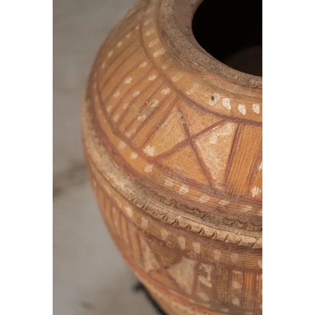Behold the exquisite rarity of this Nupe water vessel, meticulously handcrafted by the skilled artisans of the Nupe people...
