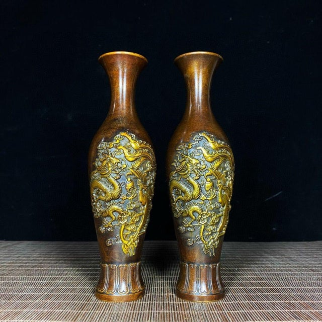 Sold as a pair, these exquisite vases feature a classic baluster silhouette with a flared rim and a fluted base. The...