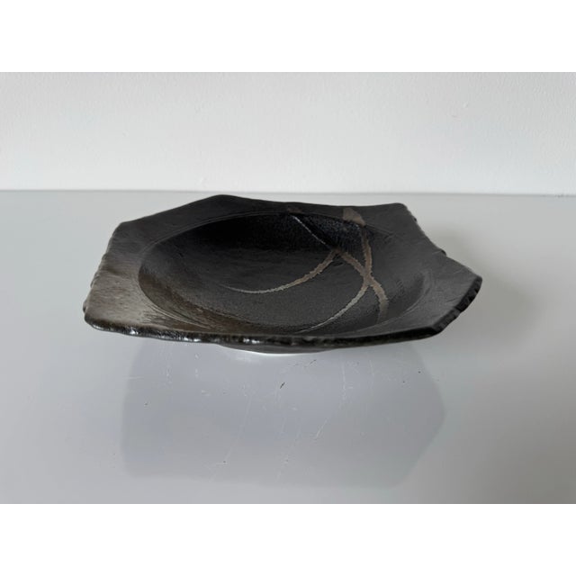This vintage handmade pottery bowl/dish features an organic, free-form design with a subtly squared rim and softly...
