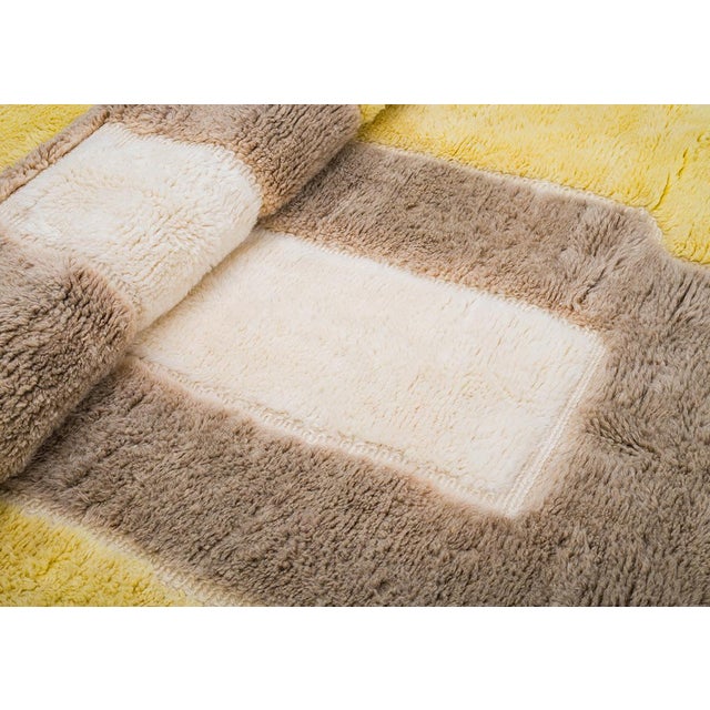 Vibrant hues of Golden Yellow, Taupe, and Ivory create a bold geometric design on this plush wool rug. The modern pattern...