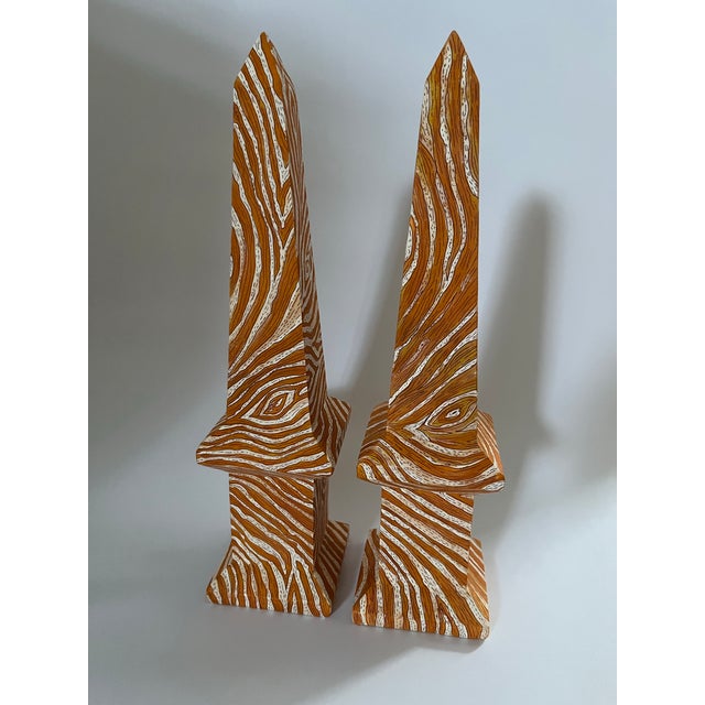 A matching pair of one of a kind decorative obelisks featuring a hand painted Chinese style faux bois design with tones of...