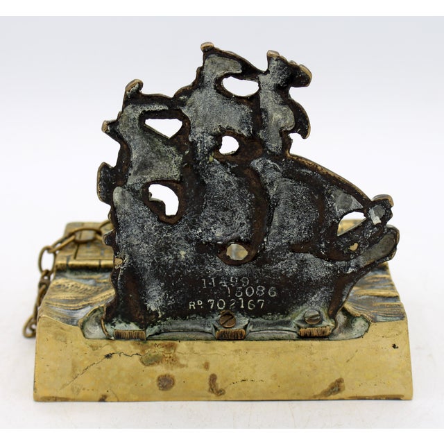 1924 brass ship inkstand, English. Featuring a Man of War in full sail just off the stone sea wall - the sea wall houses...