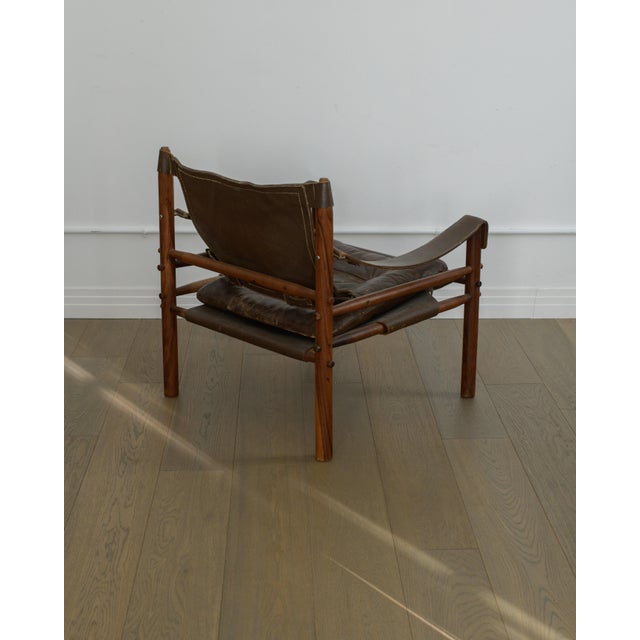 Vintage Arne Norell “Sirocco” safari chair in beautifully aged brown leather with a solid dark wood frame. Designed in...