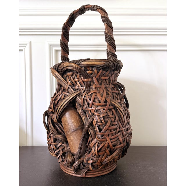 A large Japanese ikebana bamboo basket with tall handle from an unknown artist circa late Meiji Period (1868-1912). The...