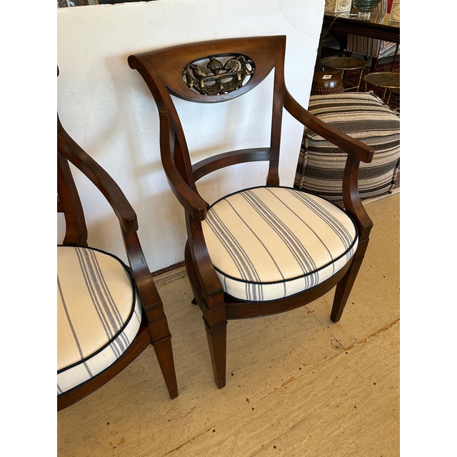 Beautiful pair of Italian dark walnut armchairs having carved wood decoration in the tops with gestural swans. Seats are...