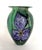 Signed Eickholt art glass vase decorated with vibrant purple flowers on a green background. Signed on the bottom. Circa...