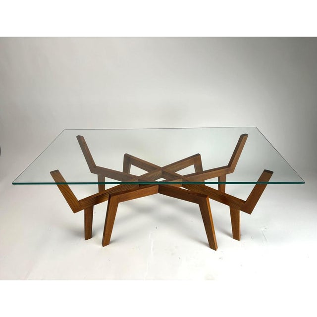 This sculptural mid-century Italian coffee table evokes the form of a spider, with its solid wood base opening into...